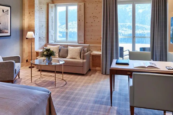 Una suite del Kulm Hotel con il soggiorno, la scrivania e le finestre sulla valle.