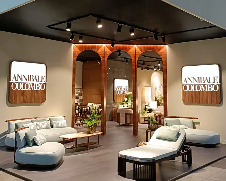 Lo stand di Annibale Colombo al Salone del Mobile 2026, con gli archi in legno e i divani.